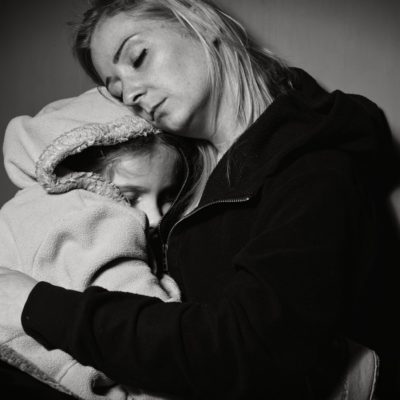 A picture of a woman holding a girl. Both have their eyes closed