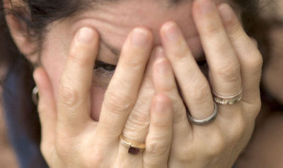 A picture of a woman covering her face with her hands