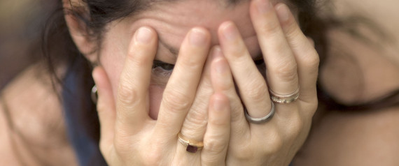 A picture of a woman covering her face with her hands