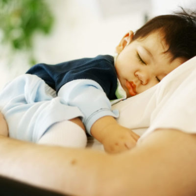 A picture of a baby sleeping on a man