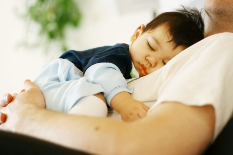 A picture of a baby sleeping on a man