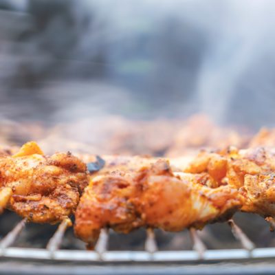 A picture of seasoned pieces of chicken on a grill