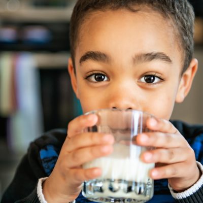 A picture of a boy drinking a glass of milk