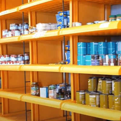 Orange shelves with canned goods stacked on them at a an Ontario food bank.