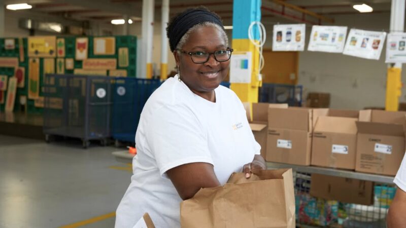 An image of Nikki McAlister, leadership award winner, in the food bank packing a hamper.