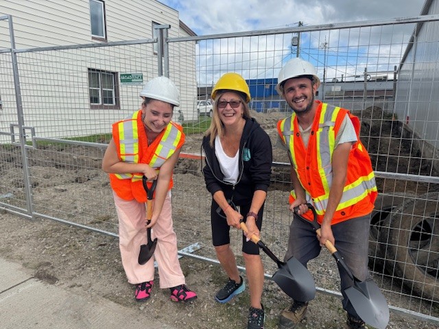 Trois personnes tiennent des pelles sur un chantier d'agrandissement de la banque alimentaire de Cochrane, un projet destiné à rendre la nourriture plus accessible aux habitants du nord de l'Ontario.
