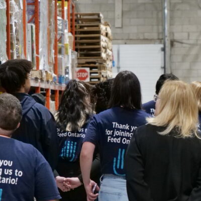 A group of people walk through a food bank.